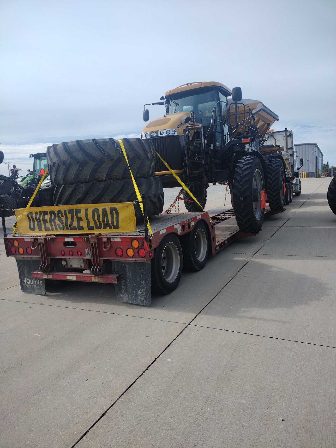 Tarped oversized cargo secured on a trailer with an OVERSIZE LOAD sign